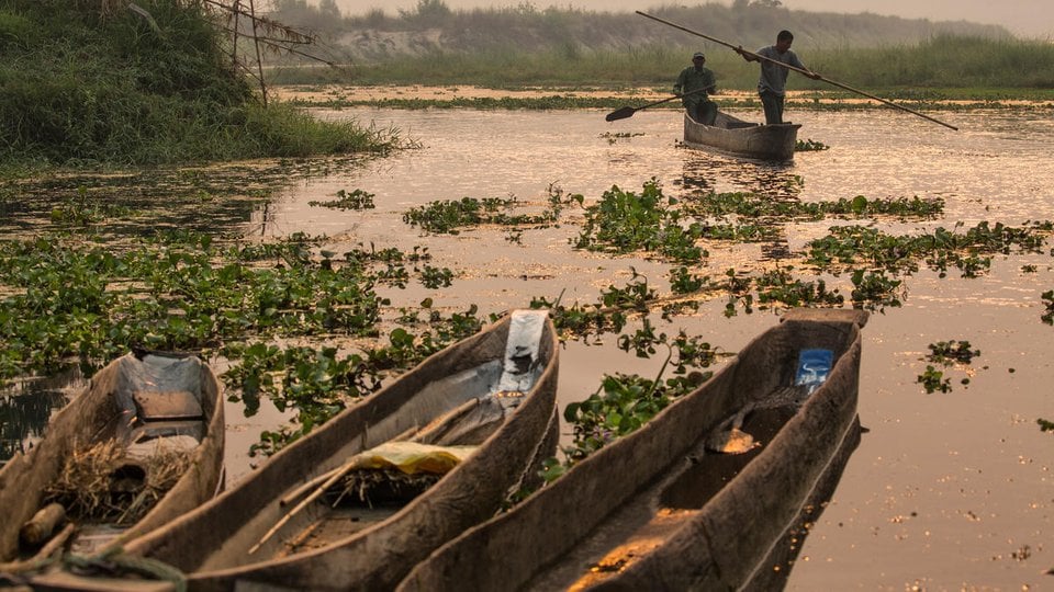 Boaters on the Rapti River just after sunrise in Chitwan National Park, Nepal