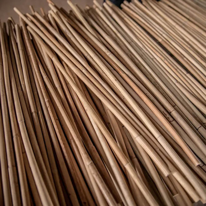 A close up of a large bundle of tan rattan cane