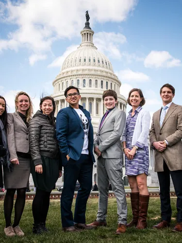 Panda Ambassadors stand in a line facing the camera in front of the US Capitol on a sunny day