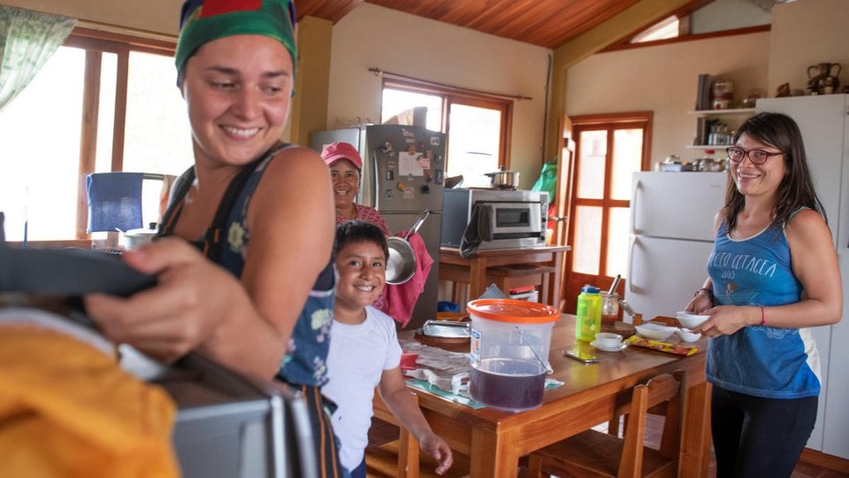 Women prepare a meal in a commercial kitchen on Floreana Island, Galapgos, Equador