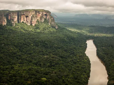 Aerial view of the Ajajú River crossing close to a tepui from the Guiana Shield at Chiribiquete National Park in the Colombian Amazon, Colombia.