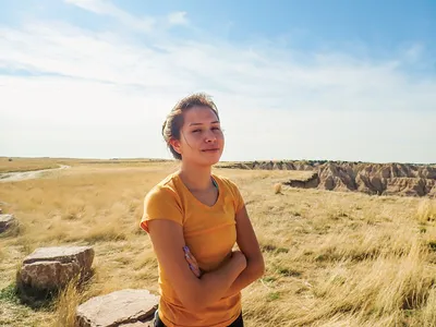 Young woman smiles at camera with rock canyons in distance