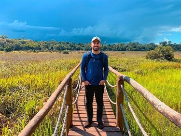 photo of Paulo Toscano standing on walking bridge over wetlands