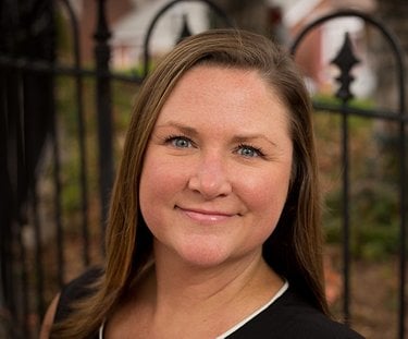 A white woman with shoulder-length light brown hair smiles.