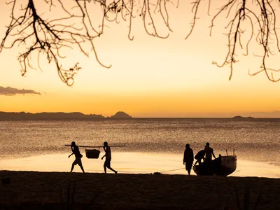 A sunset view of people bringing in the day's catch