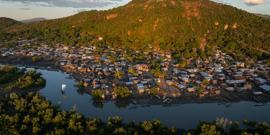 Aerial view of village on western coast of Madagascar with houses at the base of a small mountain
