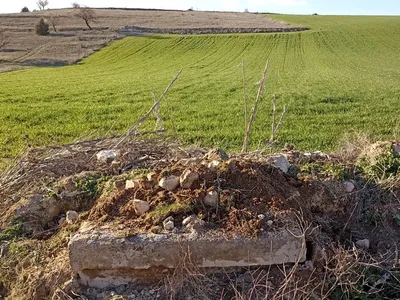 A pile of dirt and rubble over the filled hole