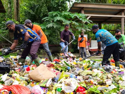 people gathering wasted food to measure