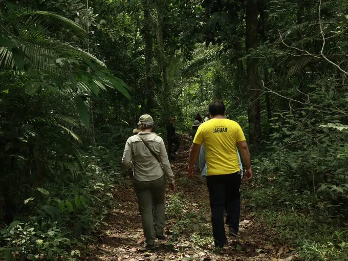 Two members of the workshop with the Indigenous Paiter Surui community walk on a path in the Amazon forest