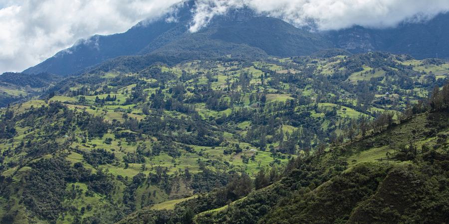 An aerial view of a mountain landscape with a hovering cloud in the PNN Chingaza buffer zone, Cundinamarca, Colombia