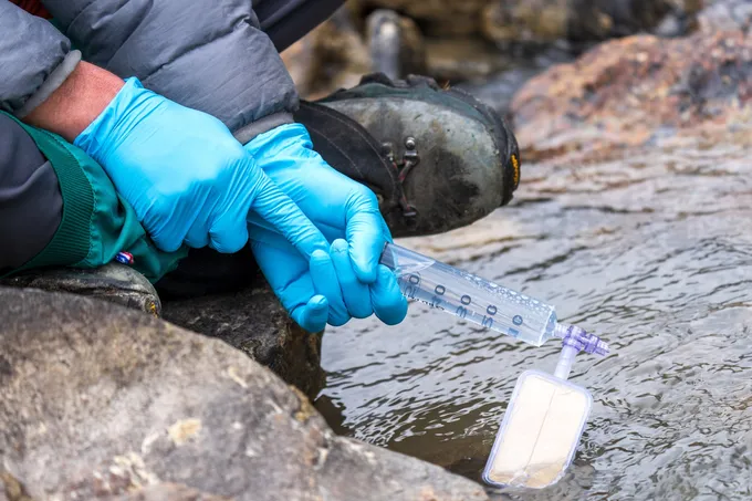 A person holds a filter in the river