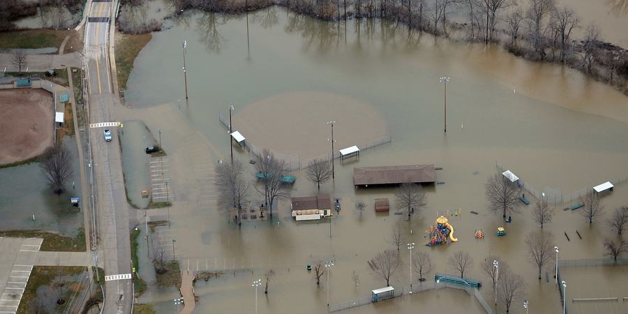 An aerial view of brownish grey water flooding homes and a road