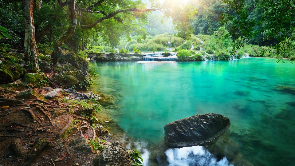 Clear turquoise river in a rain forest National Park in Guatemala Semuc Champey at sunset