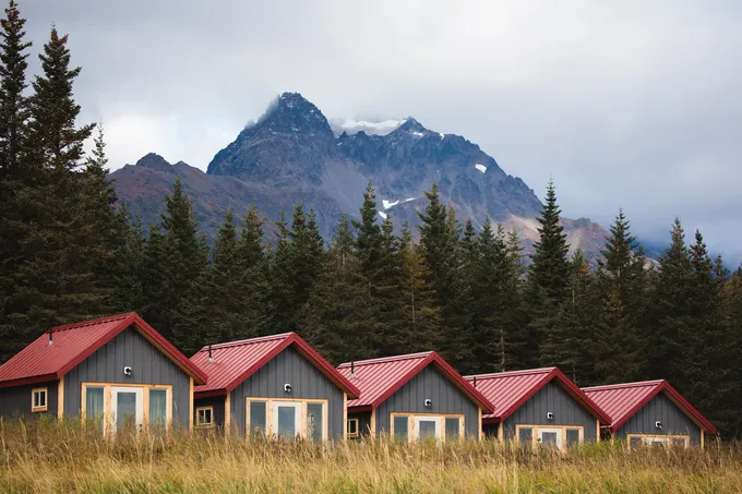 Red-roofed cabins in the foreground, mountains in the background
