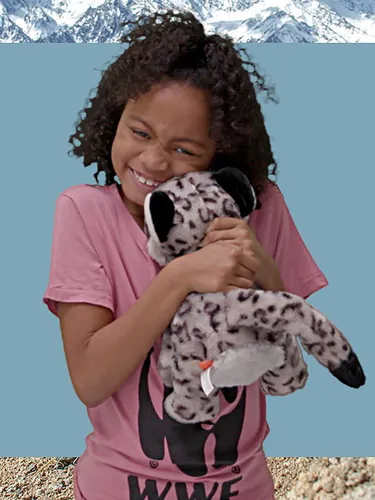 Collage of a small girl cuddling a snow leopard plush with a snow leopard on a cliff
