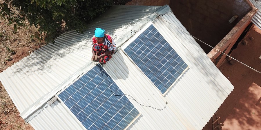Woman on roof adjusting solar panels
