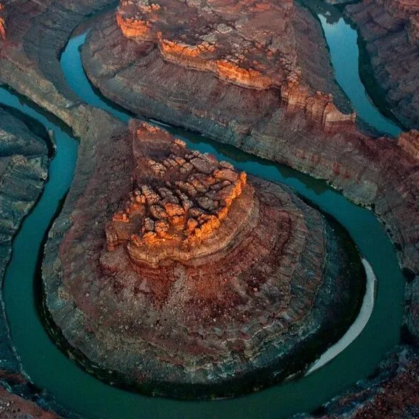 Red canyons with a blue river spiraling through it.