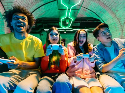 A group of friends playing a video game together on a couch