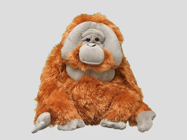 A male orangutan plush against a gray background