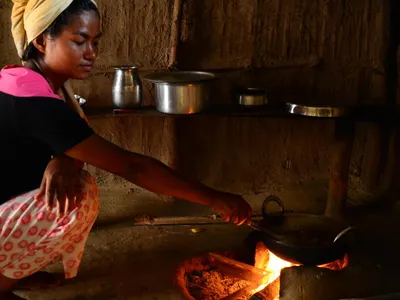 A Nepali woman cooks over her firewood stove. The use of open fires in homes can cause respiratory illness, and contribute to deforestation.
