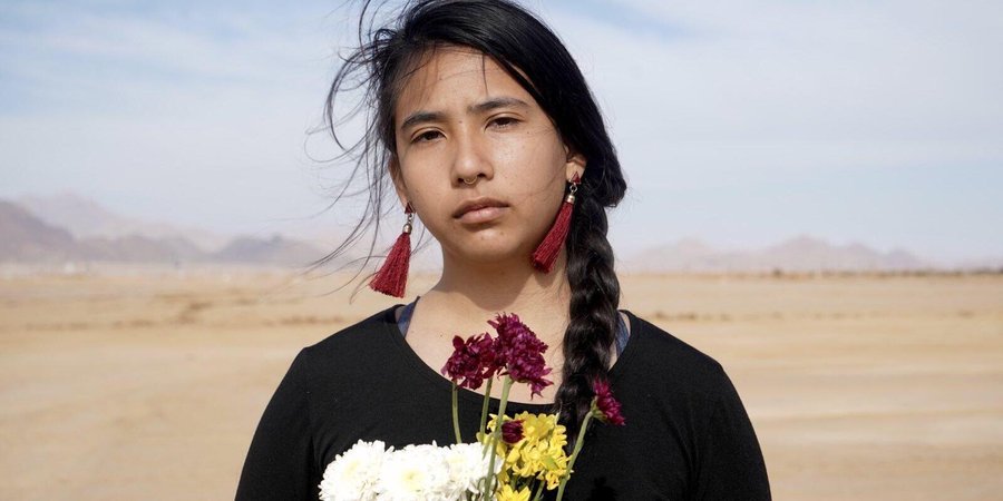 Alexia Leclercq looks at the camera while standing in the desert