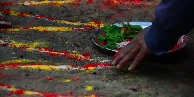 Red, yellow, and white powder spread in lines on dirt ground