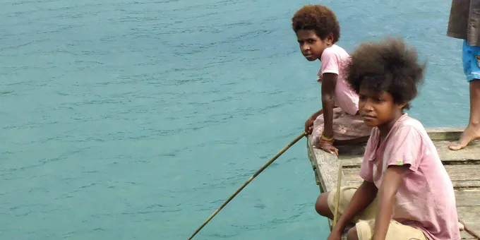 Boys on a dock in Bird's Head Seascape, West Papua, Indonesia