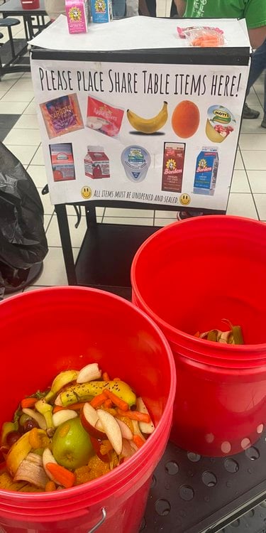 Two red buckets contain food scraps