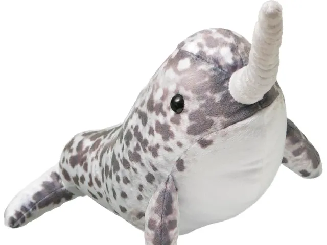 A narwhal plush against a white background
