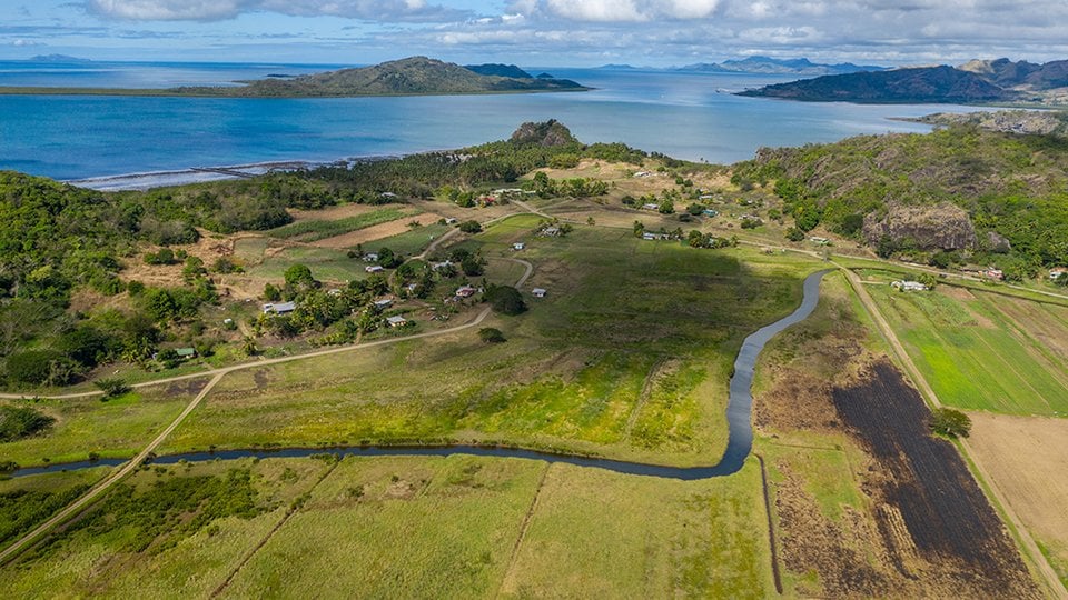 Aerial photo of village with mountains and water