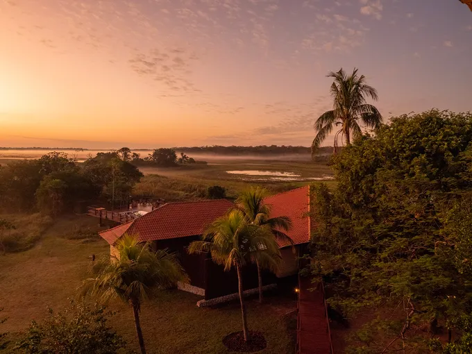A building and sunset sky surrounded by jungle