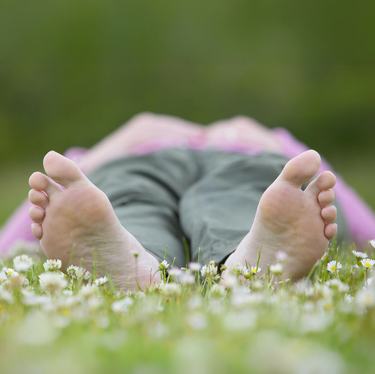 A person lying down in a field of flowers (feet only)