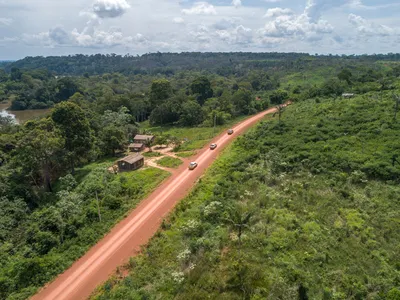 A dirt road traveling into jungle area