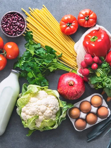 Flat lay of fruits, vegetables, greens, bread and oil in eco friendly bags, photographed from above