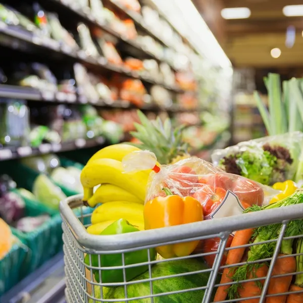 Close up of a cart full of fruit and vegetables at a grocery store