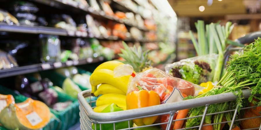 Close up of a cart full of fruit and vegetables at a grocery store
