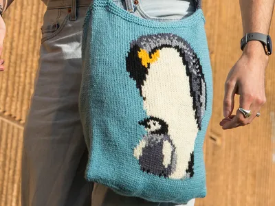 A knitted design with a penguin on a bag