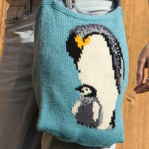 A knitted design with a penguin on a bag