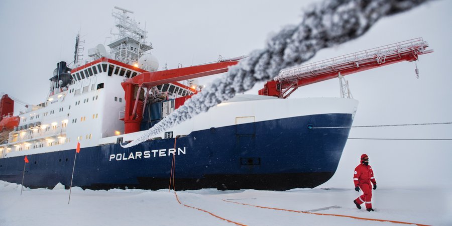 Ship in ice with crewperson walking outside