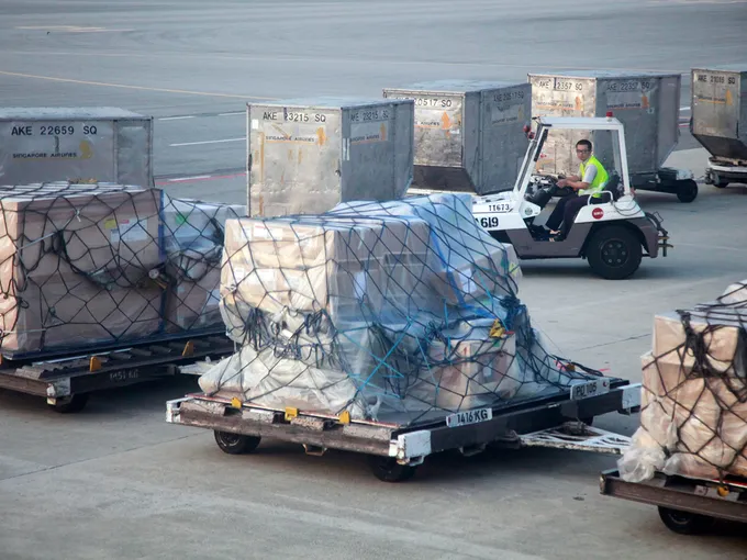 Baggage is moved across the tarmac at an airport.