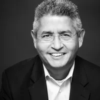 A black and white headshot of Alejandro. He is a latino man with glasses and salt and pepper hair.