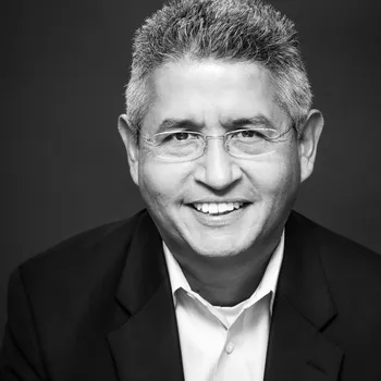 A black and white headshot of Alejandro. He is a latino man with glasses and salt and pepper hair.