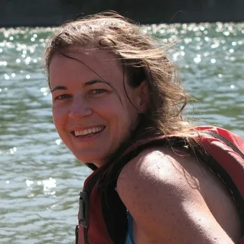 Headshot of Amanda smiling on a lake.