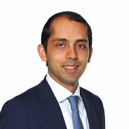 A headshot of a man in a suit and tie