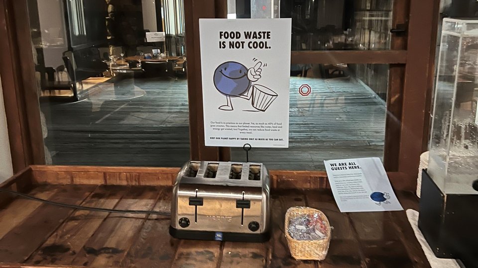 sign on a table reading "food waste is not cool"