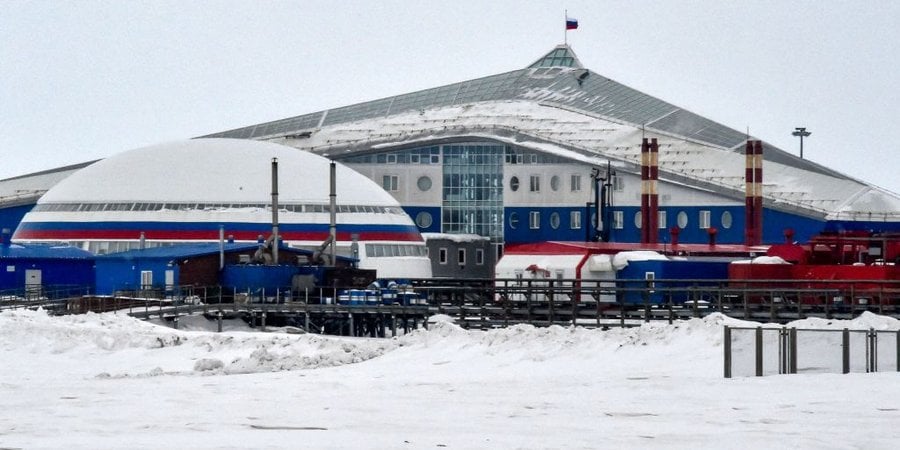 Blue, white, and red buildings in snowy landscape of the arctic