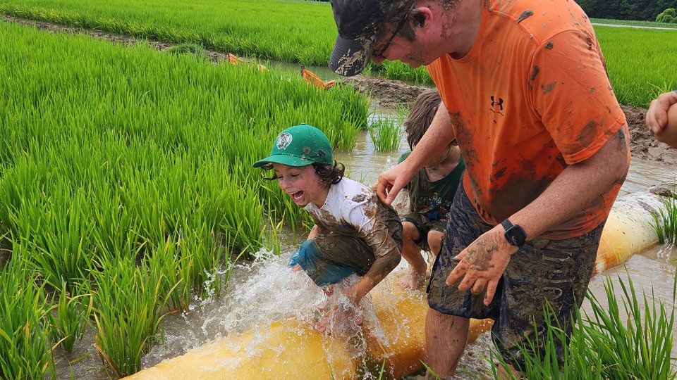 child and adult playing in flooded field