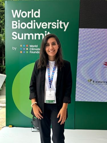Assile Beydoun stands in front of a sign that reads, "World Biodiversity Summit"
