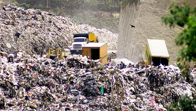 Mountain of trash with dump trucks