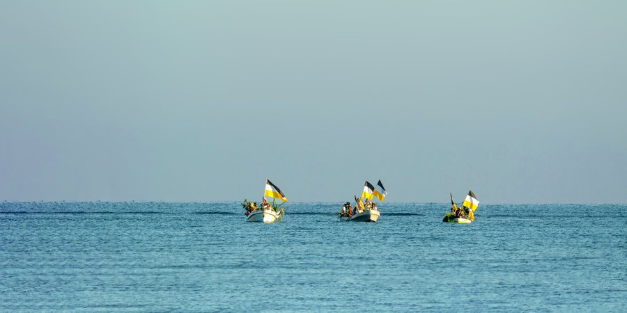 Three small boats with colorful flags